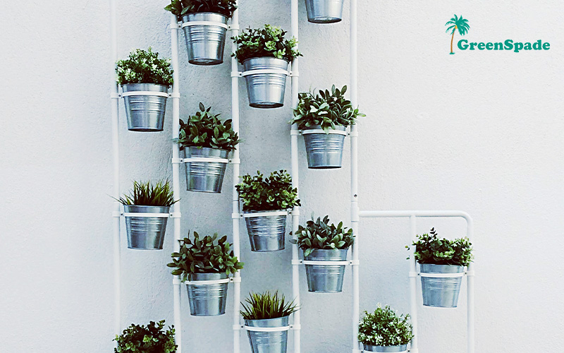 Vertical garden wall with metal pots and leafy plants